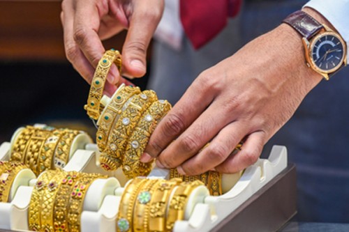 Gold gains from 1-week low as dollar declines amid peak wedding season demand